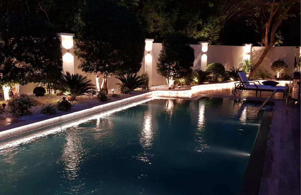 Swimming pool at night with illuminated white columns